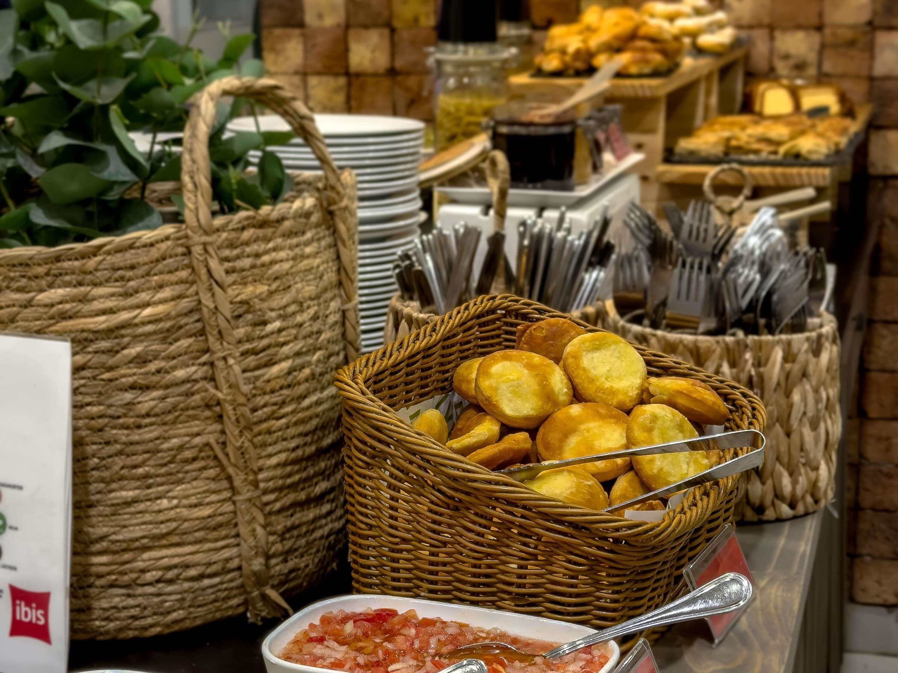 Un bufé con cestas de comida, utensilios y un letrero.