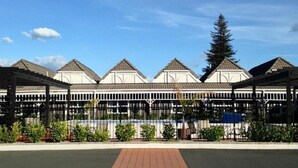 A building with a covered patio area, multiple roofed sections, and a central open space. - Lake Rotorua Hotel (Rotorua)