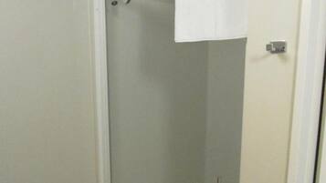 A glass-enclosed shower stall with a white towel hanging on the door.