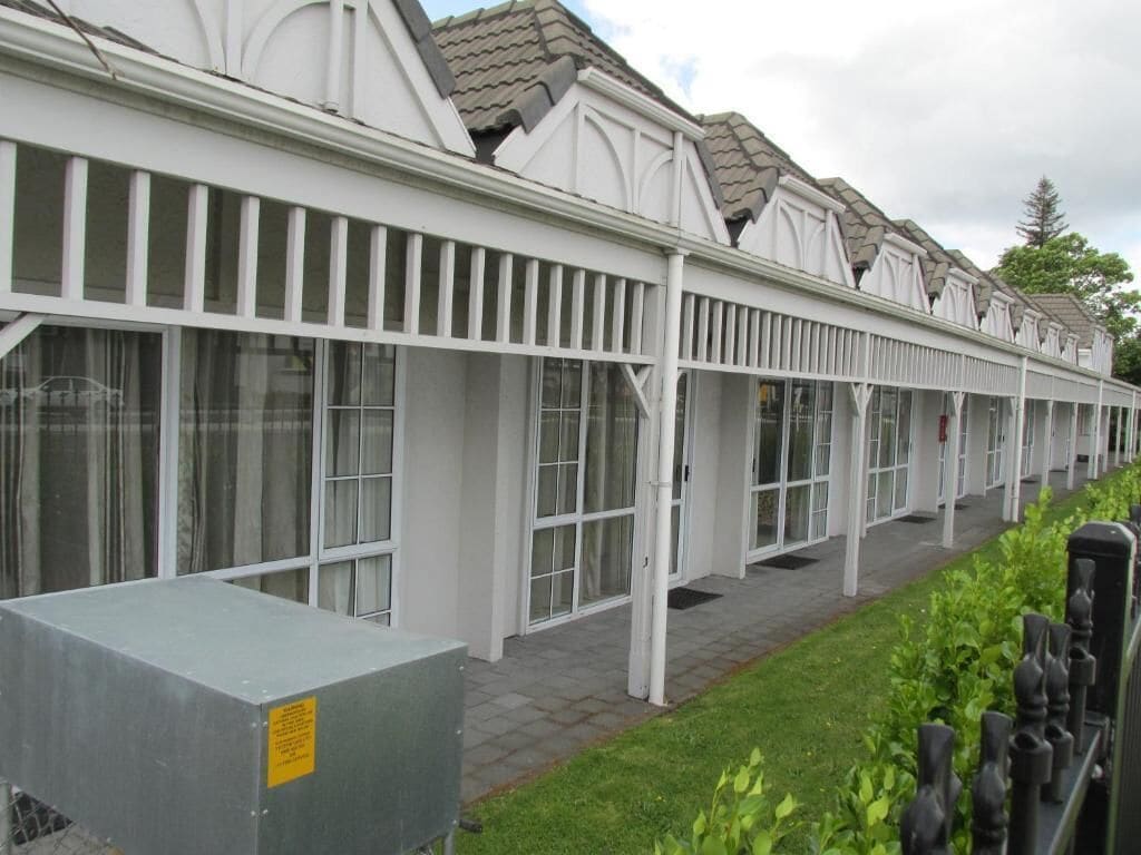A row of white buildings with large windows and a covered walkway.