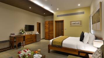 A hotel room with a bed, desk, and TV.