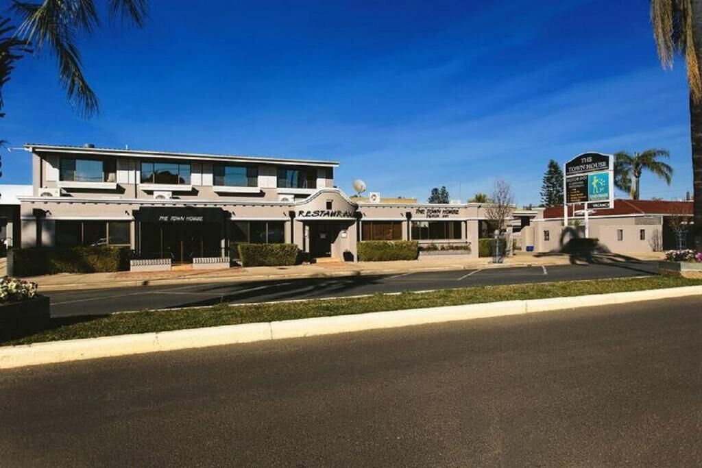 Un edificio con varias fachadas comerciales, incluyendo un restaurante y una casa de pueblo.