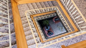 A small, enclosed balcony with a wooden railing, a potted plant, and a sofa with cushions. - The Monterey Hotel, BW Signature Collection (St. Saviour)