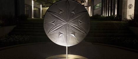 Un edificio moderno con una escultura circular e iluminada en el centro.