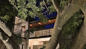 A modern building with a stone facade, a wooden deck, and lush greenery. - Hotel Boutique Casa Fernanda - Adults only (Tepoztlán)