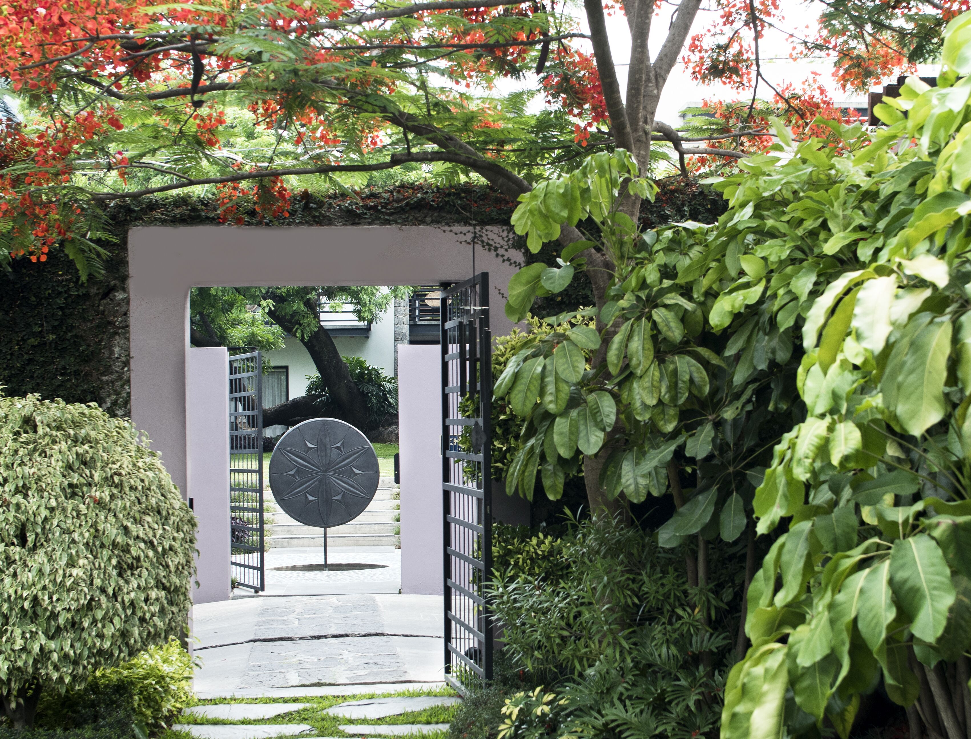 Un sendero conduce a la entrada de un edificio, con una puerta y un letrero circular.