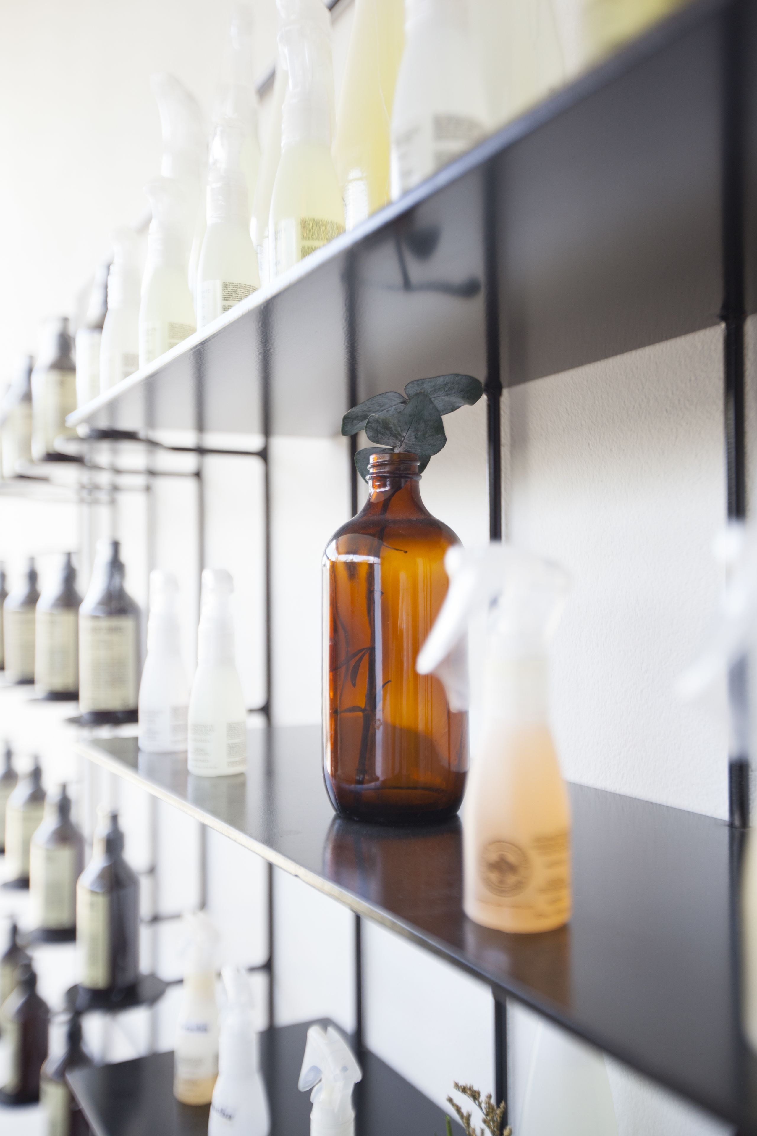 Una repisa con varias botellas y envases, probablemente para artículos de aseo o limpieza.