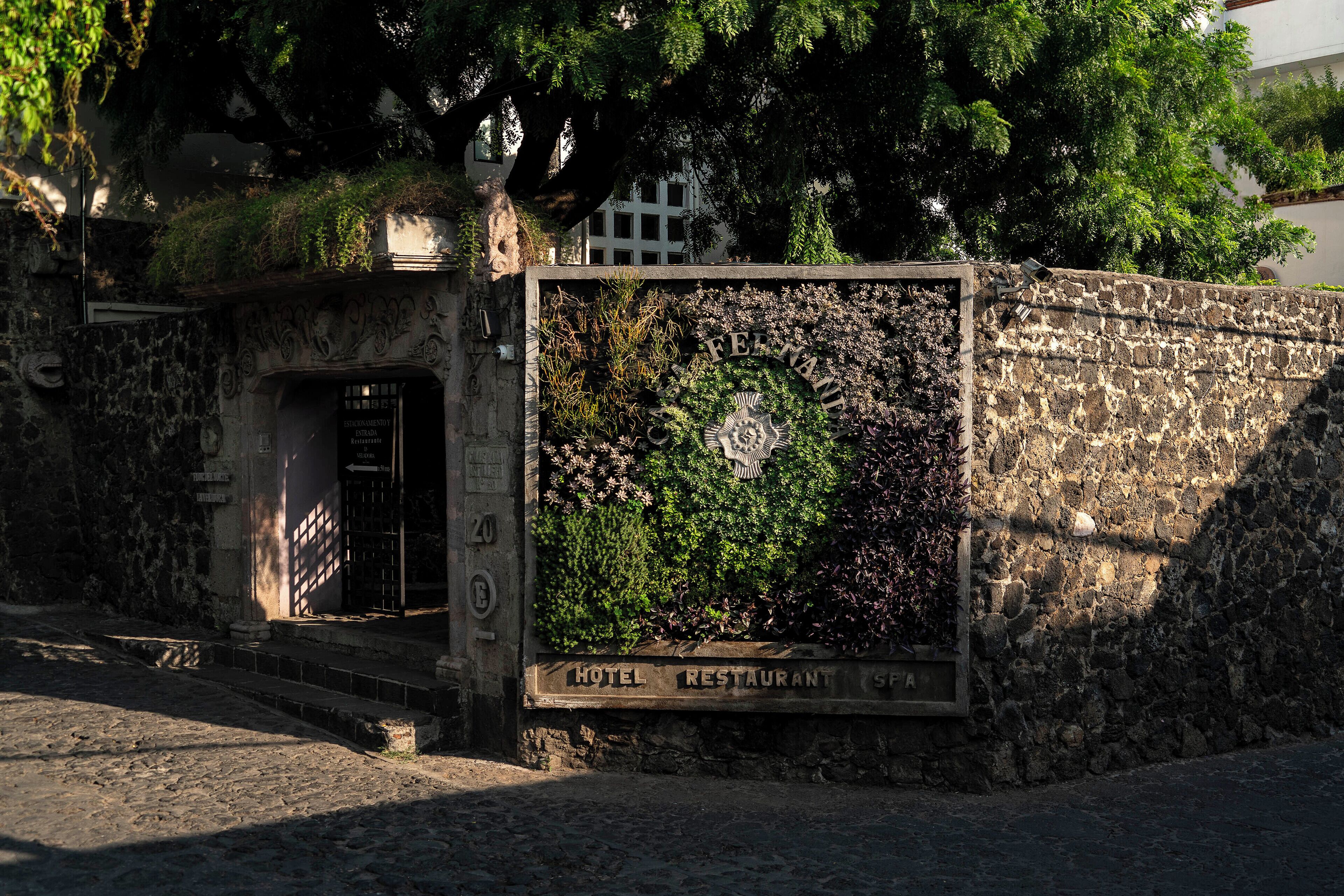 A stone wall with a sign indicating a hotel and restaurant.
