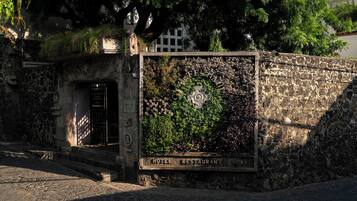 Un mur de pierre sur lequel est apposée une enseigne indiquant la présence d’un hôtel et d’un restaurant.