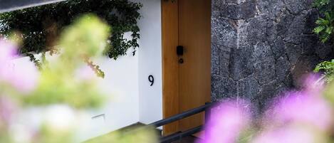 Una puerta de madera con el número 9, una pared de piedra y una barandilla de metal.