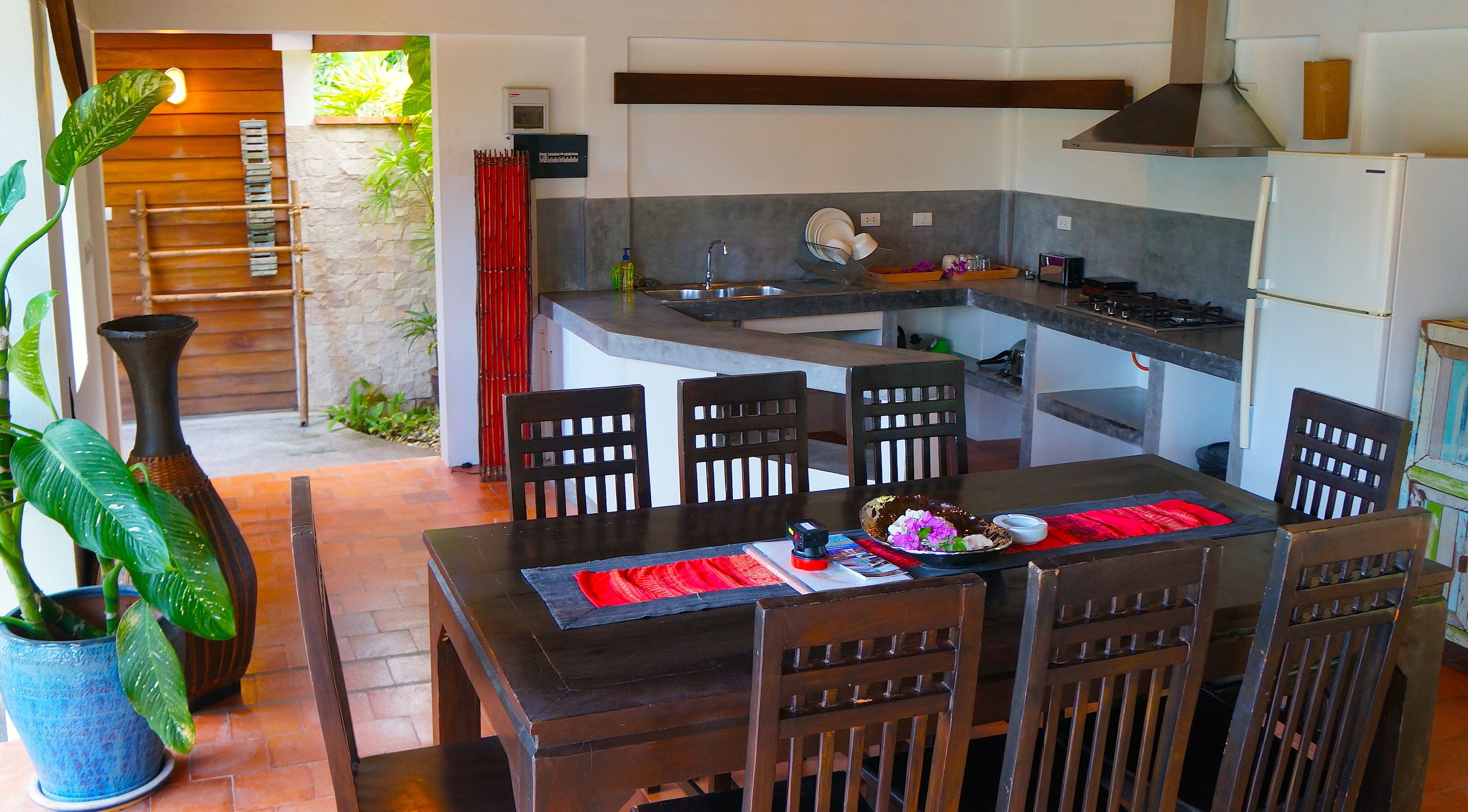 A modern kitchen with a dining area, featuring a built-in stove, sink, and a dining table with chairs.