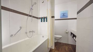 A bathroom with a bathtub, shower, toilet, and a towel rack.