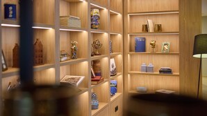 Ein ordentlich eingerichteter Raum mit Holzböden und Regalen, auf denen verschiedene dekorative Gegenstände und Bücher präsentiert werden.