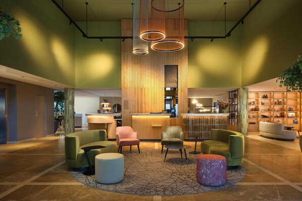 A lobby with a reception desk, seating area, and a bar.