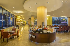 Welcome to our spacious lobby, featuring a central buffet area and comfortable seating arrangements.