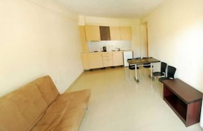A compact living space with a kitchenette, a dining area, and a sofa. - Rachoni Resort (Thasos)