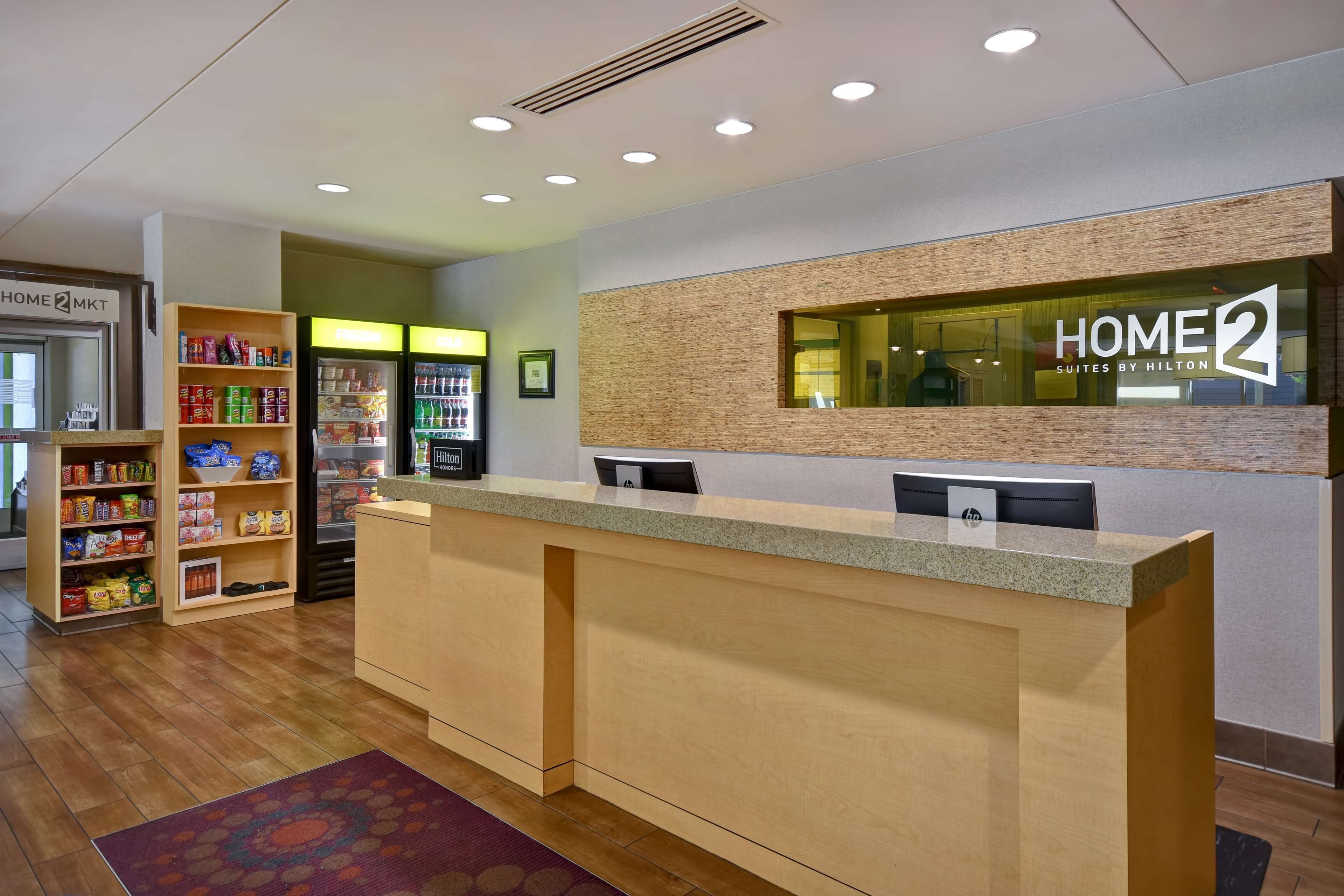 A hotel reception area with a reception desk, a vending machine, and a snack shelf.
