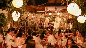 A formal outdoor dining area with tables and chairs, a band performing, and a decorated backdrop. - Cattleya Suite by Marbella (Keroboken Kelod)