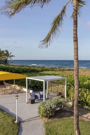 A patio area with outdoor furniture, a grill, and a view of the ocean. - Delray Breakers on the Ocean (Delray Beach)