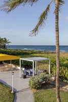 Un espacio de patio con mobiliario exterior, una parrilla y vistas al océano.