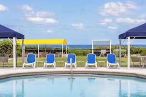 Una piscina al aire libre, camas de piscina gratis, sombrillas