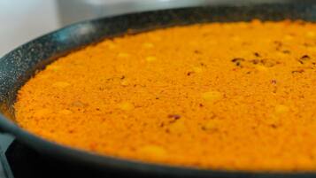 A close-up of a pan filled with a yellow-orange mixture, possibly a food preparation.
