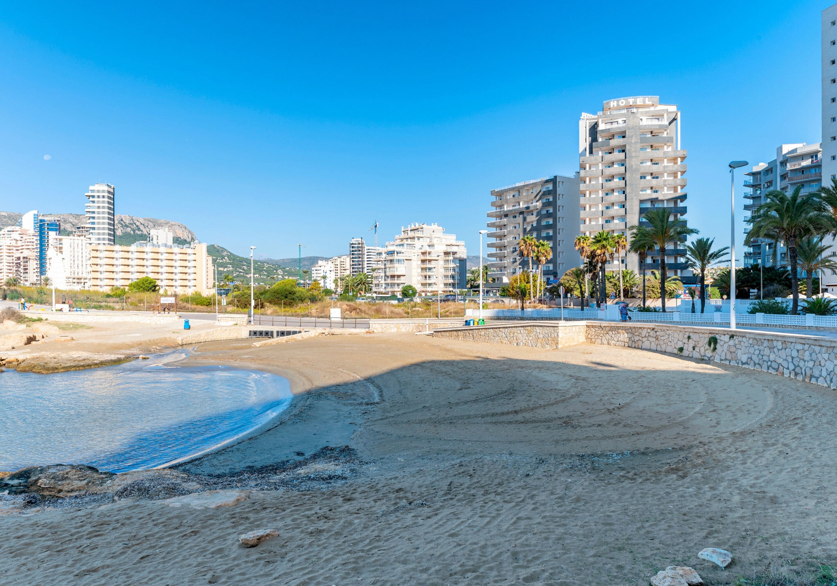 A beach with a hotel in the background.