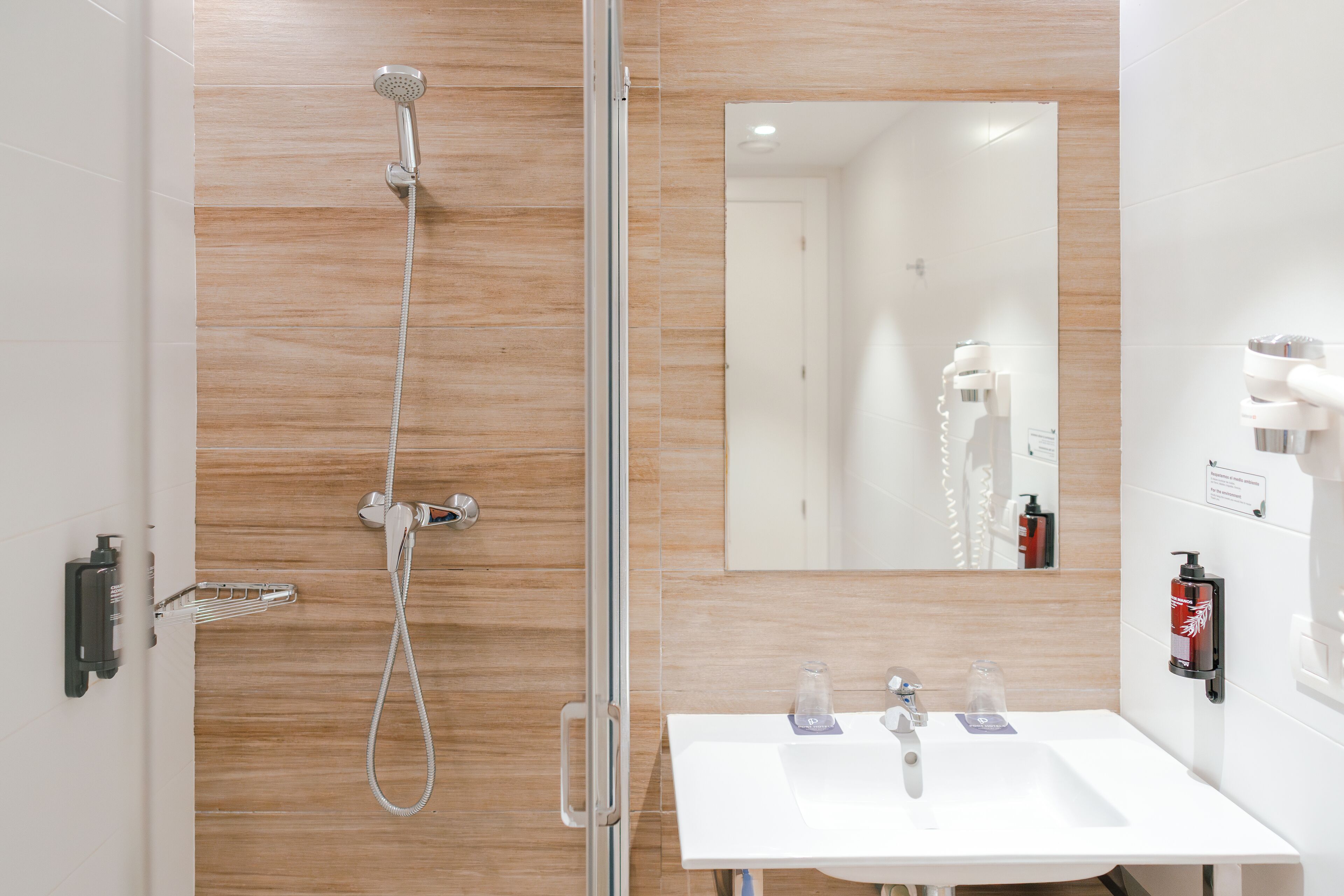 A bathroom with a shower, sink, and mirror.