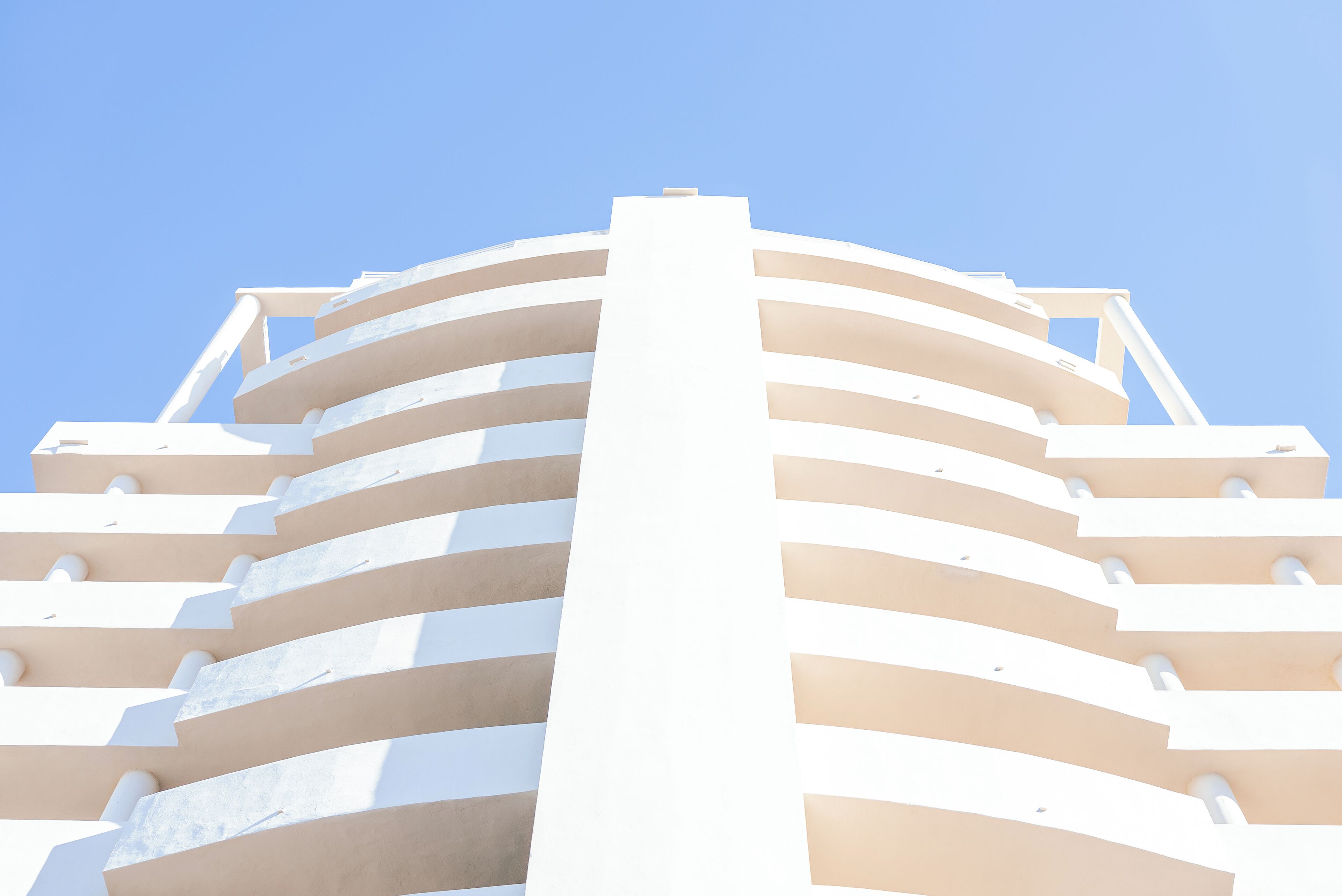 Un edificio moderno con fachada curva y varios balcones.