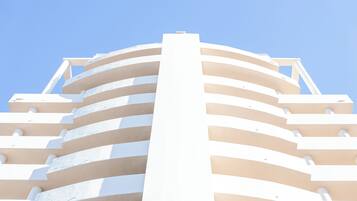 Un bâtiment moderne doté d’une façade incurvée et de nombreux balcons.