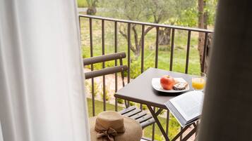 Een balkon met een ontbijttafel, inclusief een bord met eten en een glas sinaasappelsap.