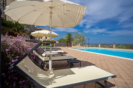 Una piscina al aire libre de temporada, sombrillas. Tenuta Ciminata Greco