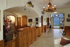 Una cocina amplia con armarios de madera, una isla grande y vista al mar a través de un vano abierto.