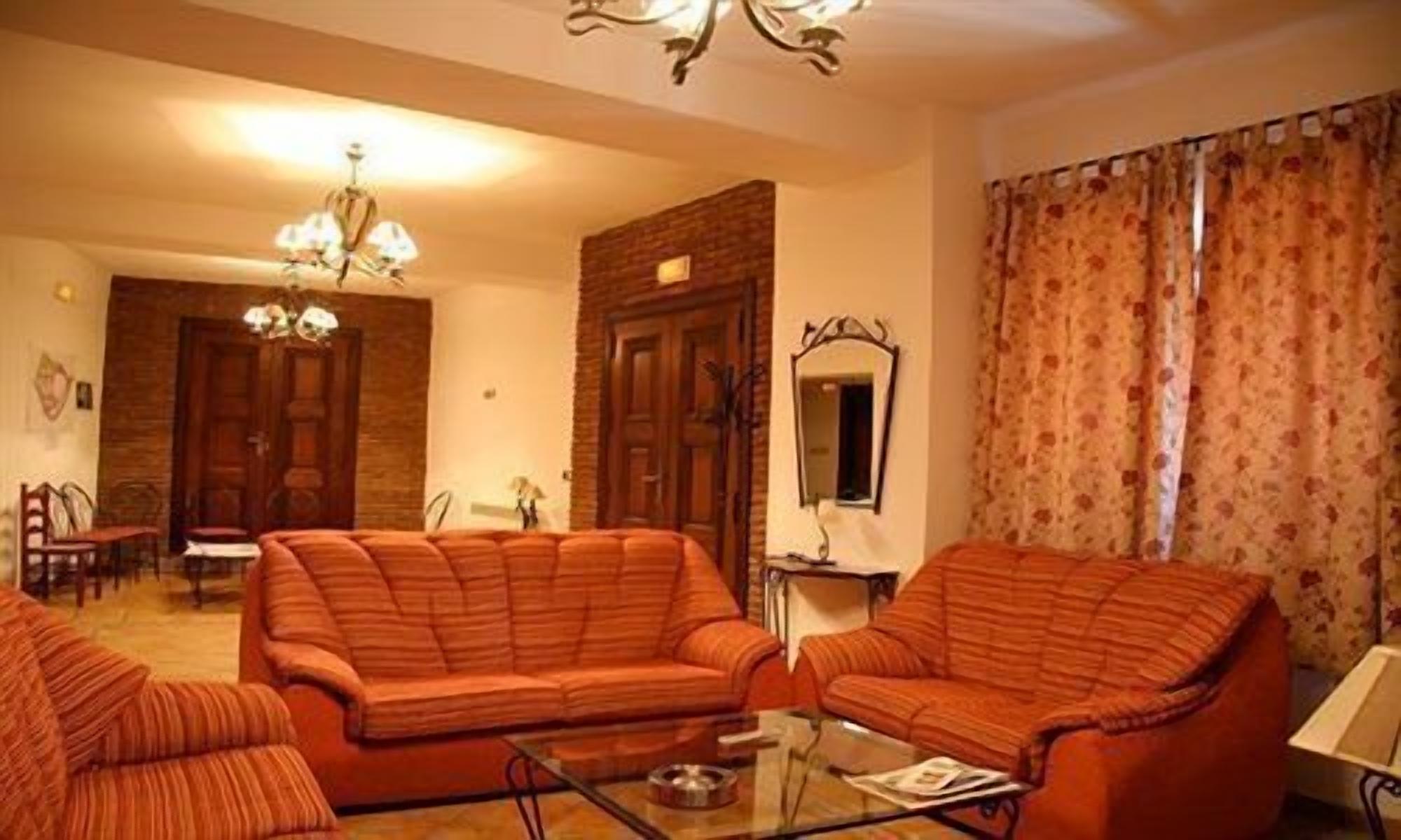 Una sala de estar con un sofá, una mesa de centro de vidrio y una araña.