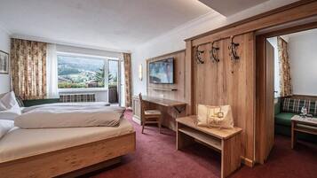 Una habitación de hotel con cama, escritorio, televisión y vistas al exterior.