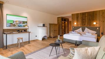 Ein Hotelzimmer mit einem Bett, einem Schreibtisch mit Computer, einem Fernseher und einer Holzwand.