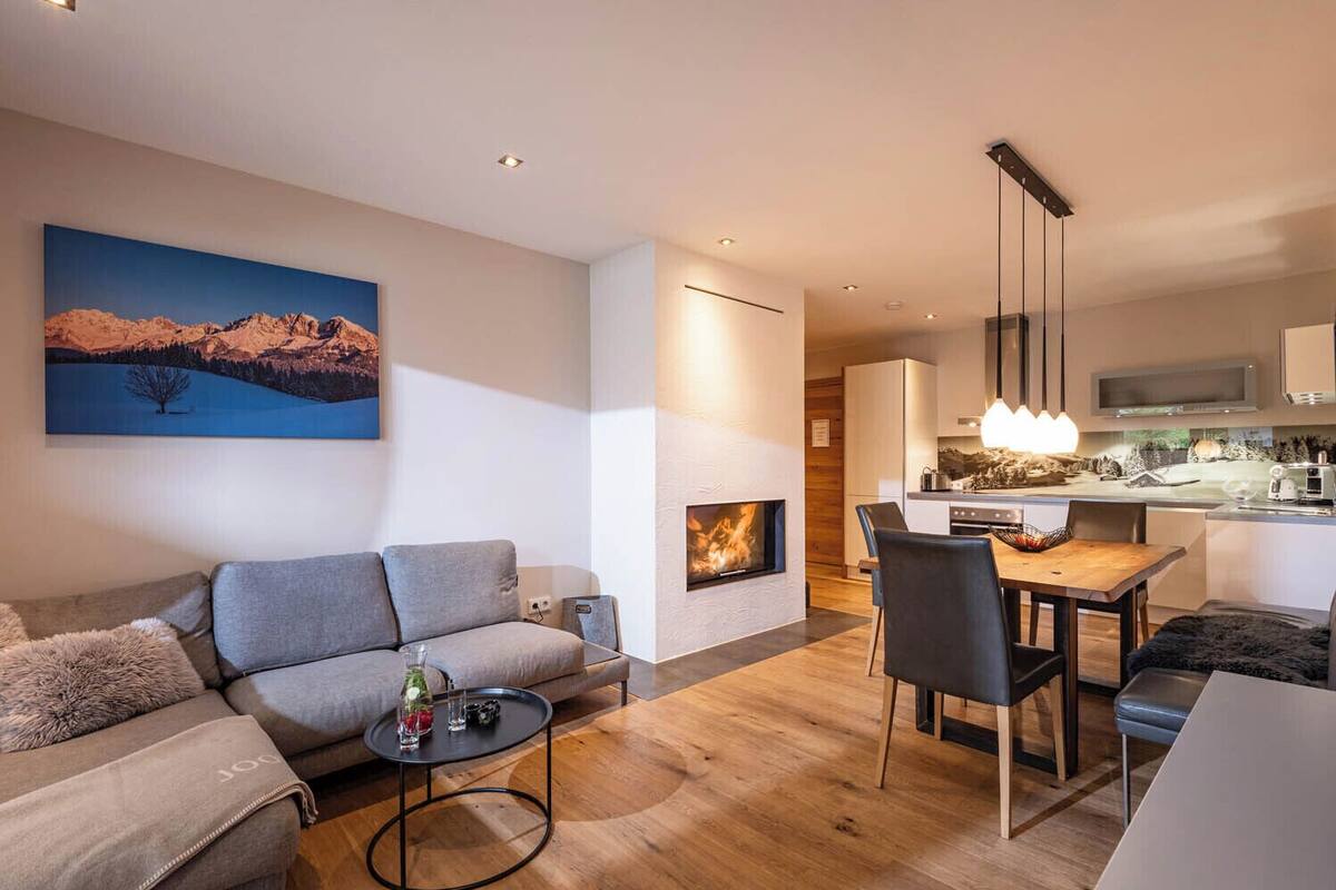 A modern living room with a sofa, coffee table, and fireplace.