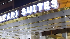 A hotel sign with the name "SUKARI SUITES" in large letters.