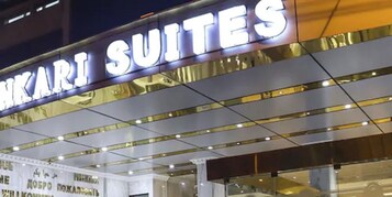 Un letrero de hotel con el nombre 'SUKARI SUITES' en letras grandes.