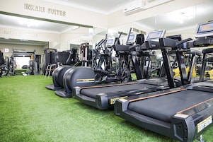 Un gimnasio con cintas de correr, bicicletas estáticas y máquinas de pesas.