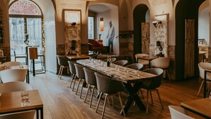 Un restaurante con una larga mesa de madera dispuesta para comer, rodeada de sillas.