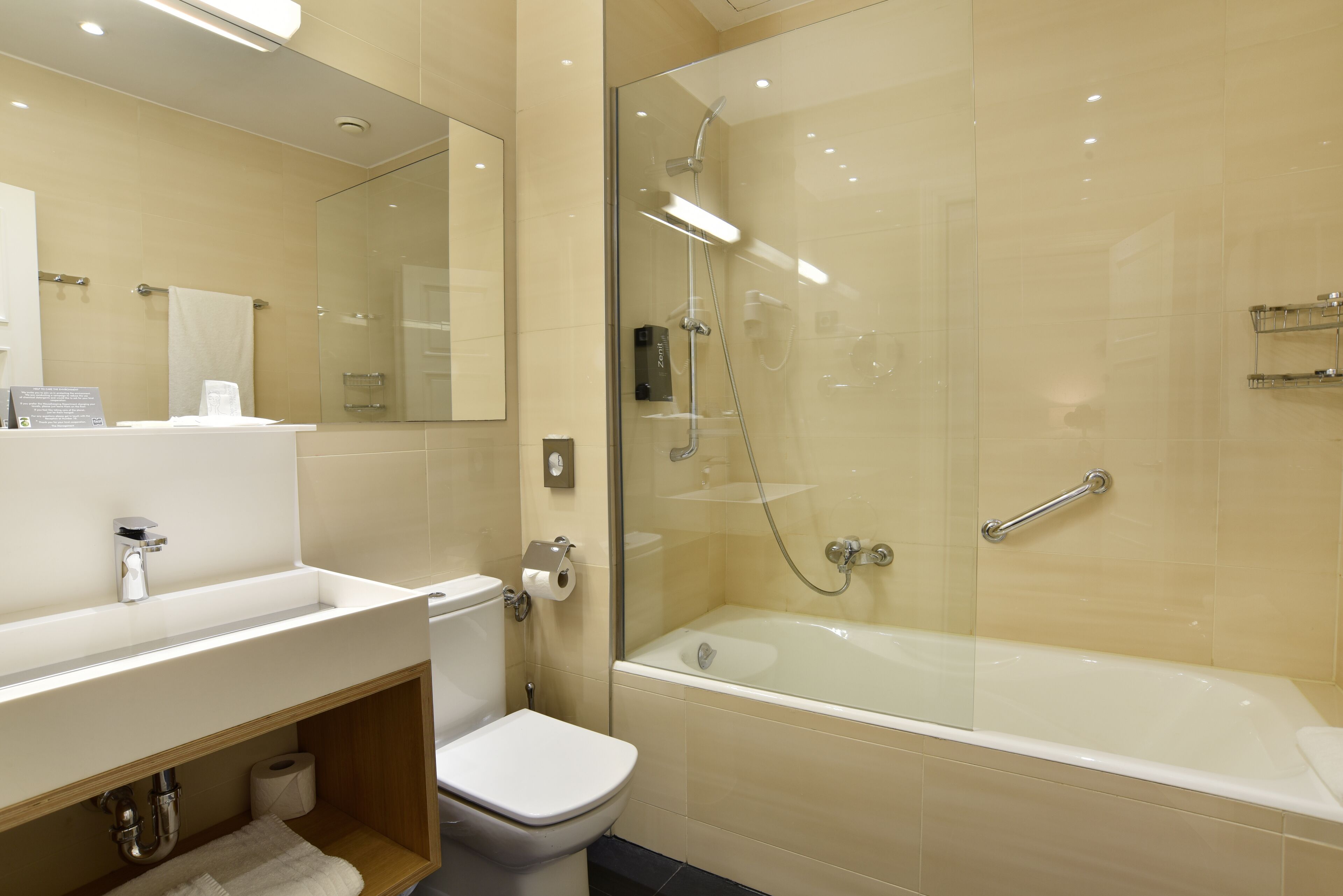 A modern bathroom with a glass-enclosed shower, a bathtub, a toilet, and a vanity with a mirror.