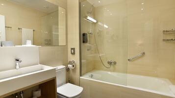 A modern bathroom with a glass-enclosed shower, a bathtub, a toilet, and a vanity with a mirror.
