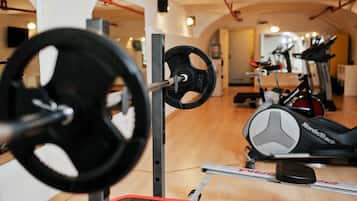 Uma academia com equipamentos de musculação, esteiras e bicicletas ergométricas.