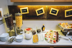A buffet setup with labeled sections for cereals, jams, sweets, and French toast. - Hotel Zenit Budapest Palace (Budapest)