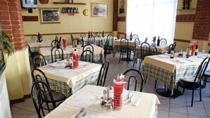 A restaurant with multiple tables, each covered with a checkered tablecloth. - Hotel Cavallo Bianco (Novara)