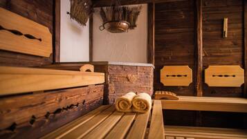 A rustic wooden sauna with benches and a brick wall.
