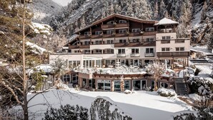 A multi-story hotel with balconies, a covered outdoor area, and snow-covered surroundings. - Hotel Rita (Laengenfeld)