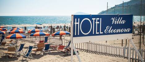 A beachside hotel sign with "HOTEL Villa Eleonora" written on it.