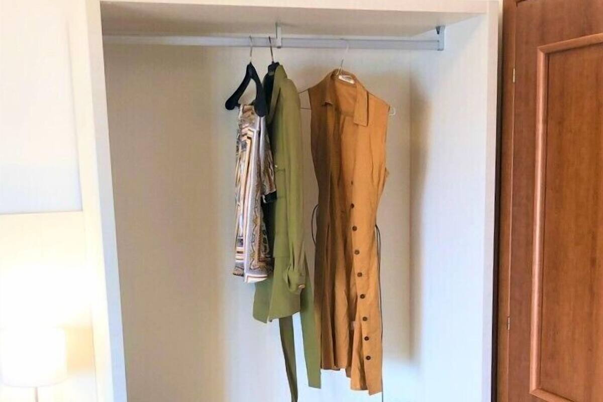 A walk-in closet with hanging space and drawers.